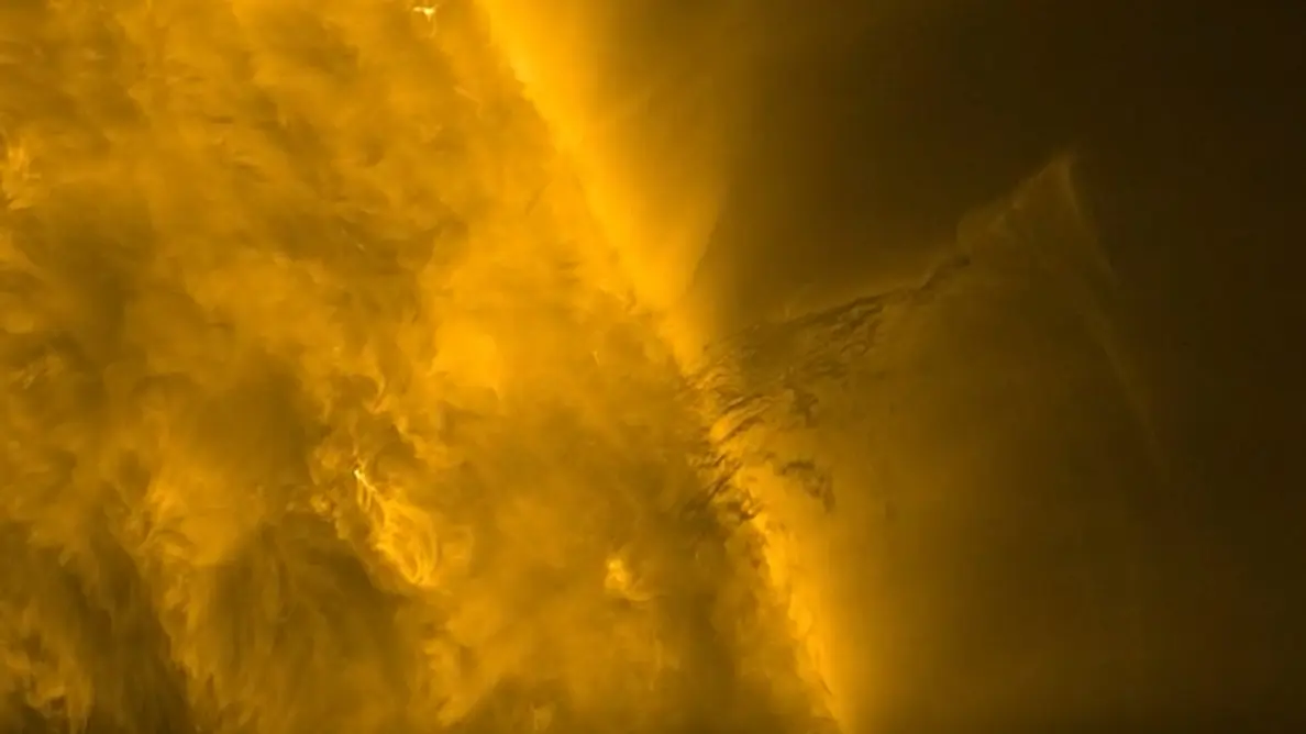 ویدئوی نزدیک از خورشید که نصف سمت چپ تصویر را پوشانده است؛ سطح آن پوشیده از موهای درخشان و متحرک شبیه به پرهای نورانی به همراه قوسهای روشن کوتاهمدت. در مرکز ویدئو، به سمت راست، ماده تاریکی شبیه پرهای ریز، با خطوط نازکی که هم به سمت خورشید و هم از آن دور میجوشند، دیده میشود.