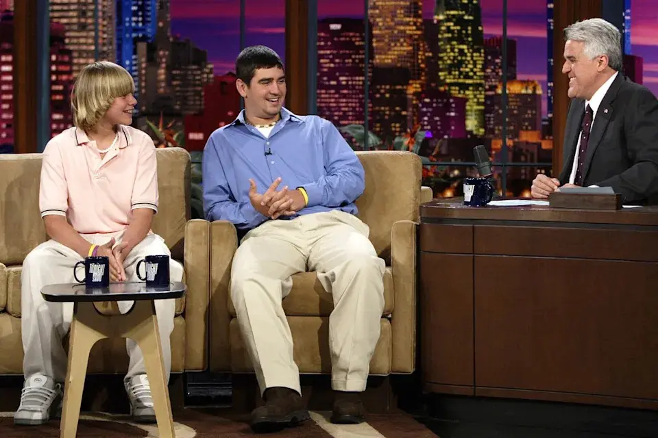 Paul Drinkwater/NBCU Photo Bank/NBCUniversal via Getty؛ تراوی دریسکول (چپ) و جاش لانگ (راست) در مصاحبهای با جی لنو در ۱۷ مه ۲۰۰۵.